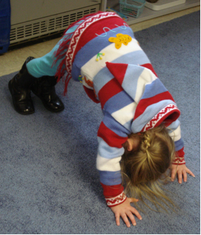 Child does Downward Dog yoga pose